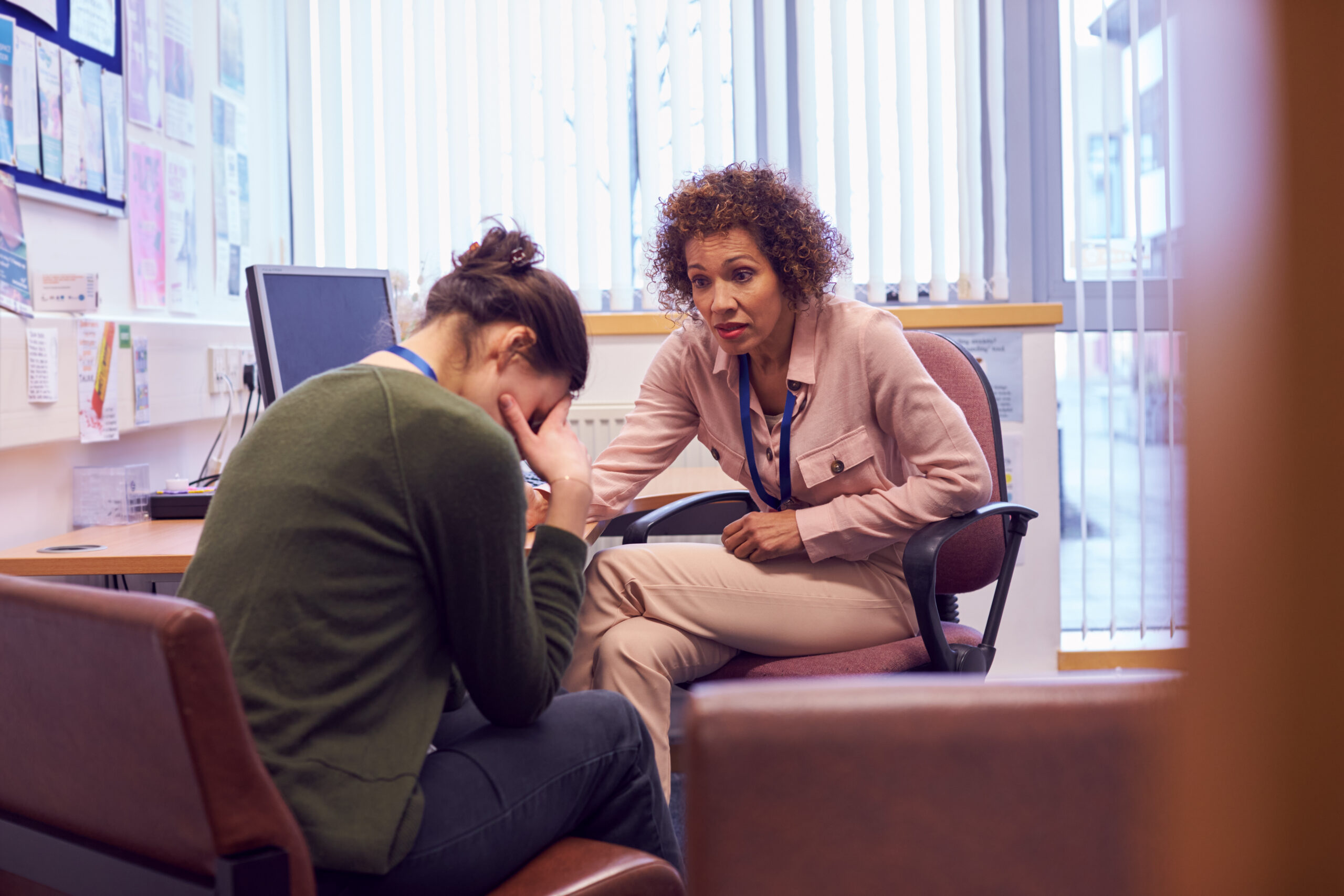 Female College Student Meeting With Campus Counselor Discussing Mental Health Issues