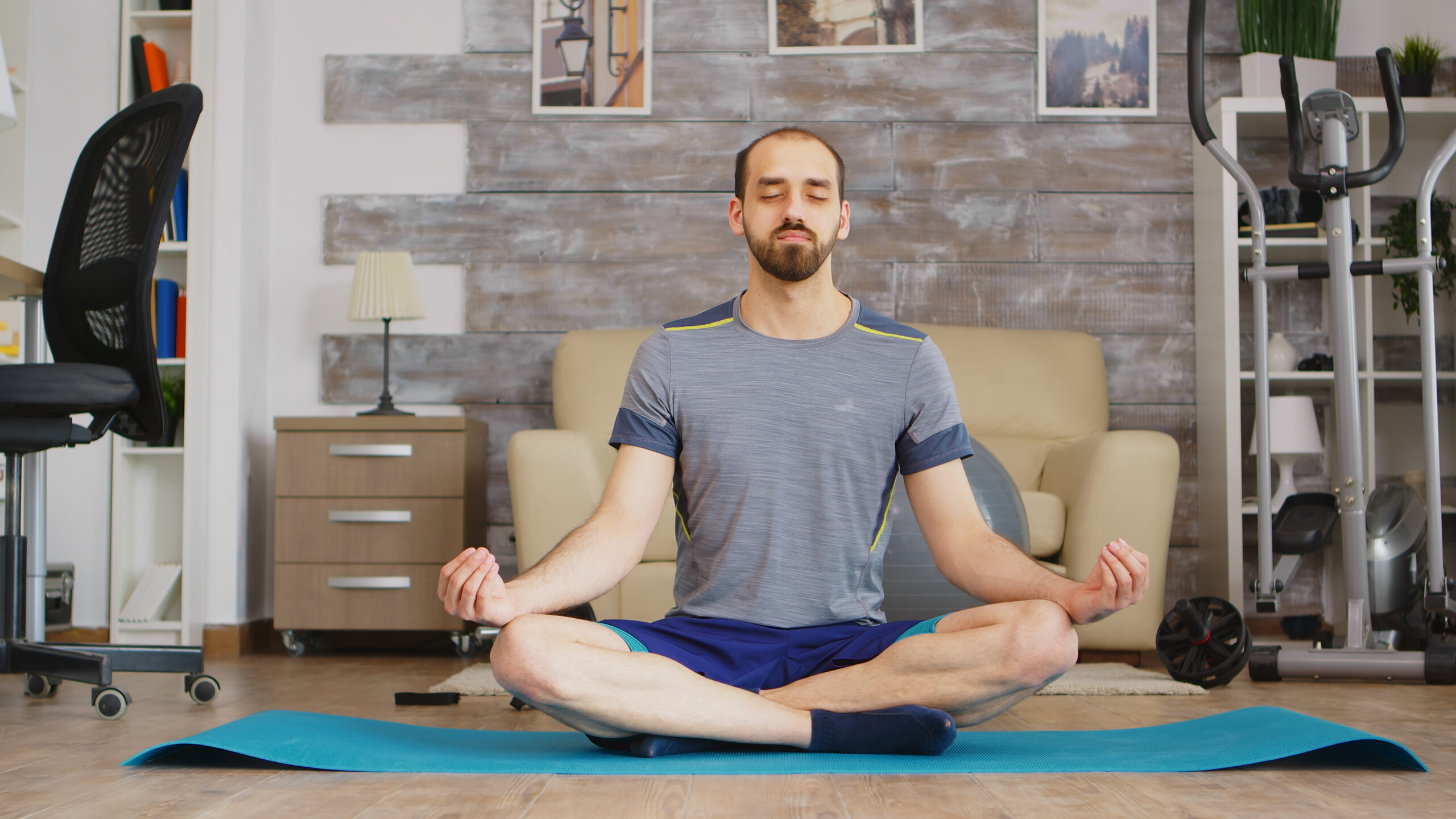 Man practicing mindfulness on yoga mat in cozy living room.